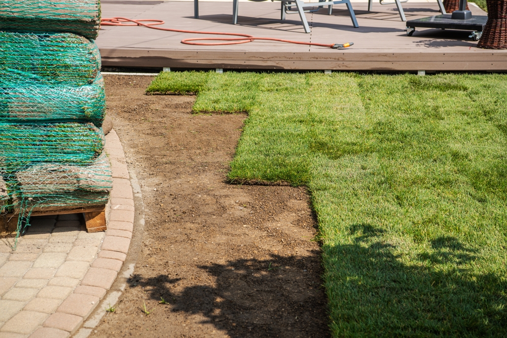 sod installation crew leveling soil and laying turf